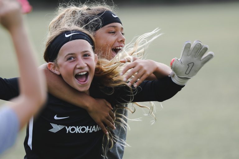 goalkeeper and field player smiling and laughing