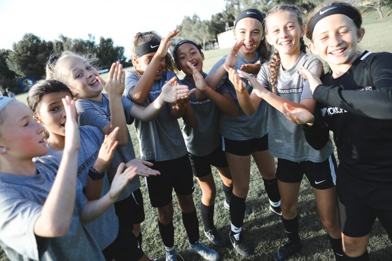 huddle of Slammers FC girls clapping